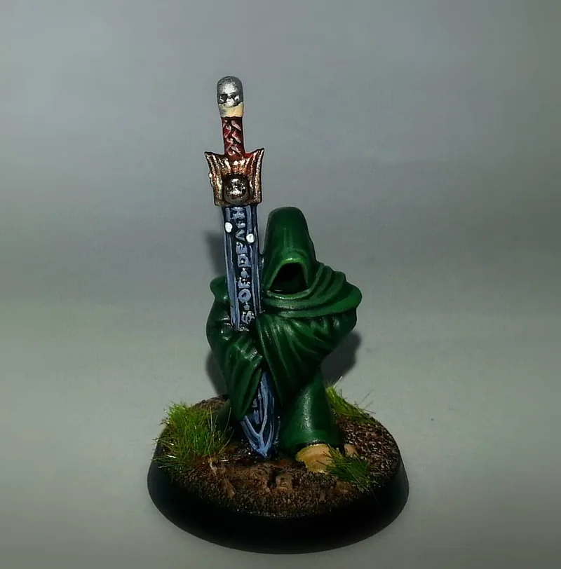 Figura encapuchada con espadón rúnico
